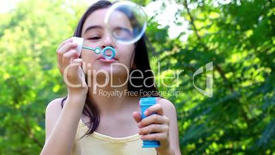 Little cute girl blowing soap bubbles