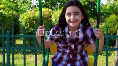 Little girl smiling on a swing