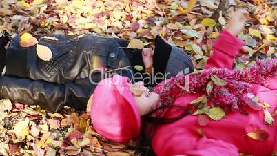Two girls lying on top of leaves