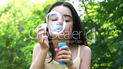 Teenager blowing colorful bubbles soap
