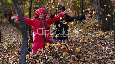 Girls playing in autumn park with leaves