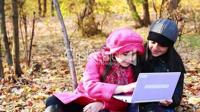 Two girls playing on laptop