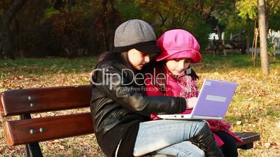 Two girls playing on laptop