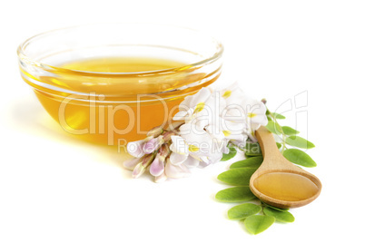 Honey in spoon with acacia and glass bowl