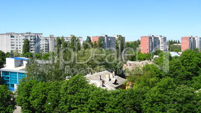 panorama of city with multystorey houses and many green trees