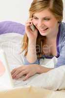 Cheerful teenage girl with phone and laptop