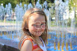 little sympathetic girl on the background of fountains