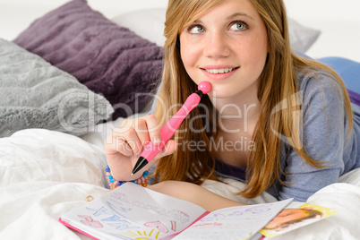 Daydreaming teenager girl writing her journal
