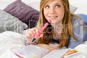 Daydreaming teenager girl writing her journal