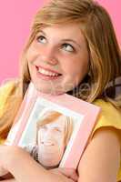 Teenage girl embracing picture of her boyfriend
