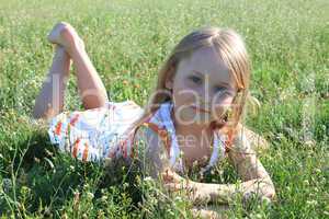 portrait of little girl lying on the grass