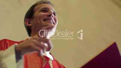 Catholic priest on altar talking to people in church