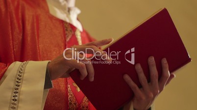 Man and spirituality, young catholic priest serving mass, holding Bible