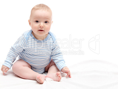 Child sitting on white bed