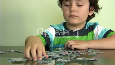 Little boy solving puzzle