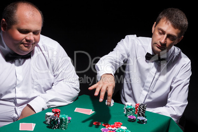 Two gentlemen in white shirts, playing cards