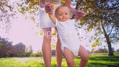 Mom Helping Baby Take First Steps