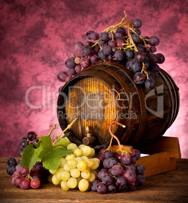 White and red grapes with wine barrel