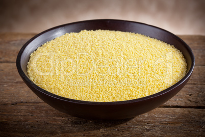 raw couscous in a wooden bowl