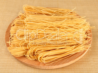 Raw italian pasta on wooden tray
