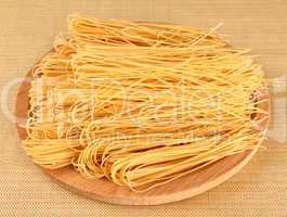 Raw italian pasta on wooden tray