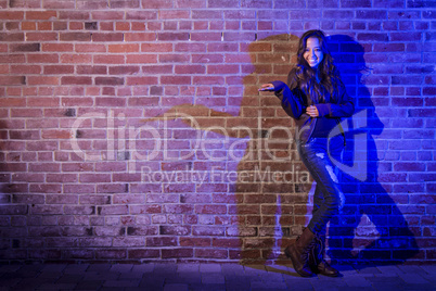 Mixed Race Woman Holding Her Hand Out Against Brick Wall