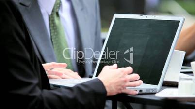 Business People Using Laptop at Outdoor Caf