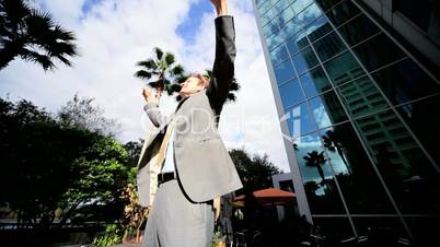 Businessman Triumphant Outside City Buildings