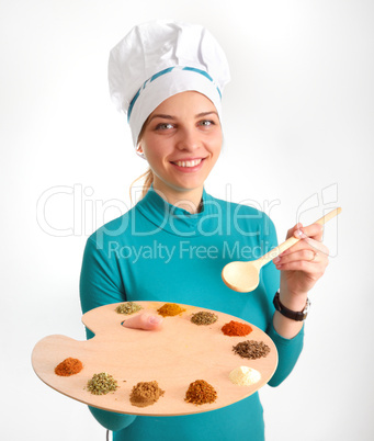 Spices and herbs on the palette and cook gir