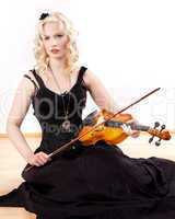 Woman sitting on the floor and plays violin