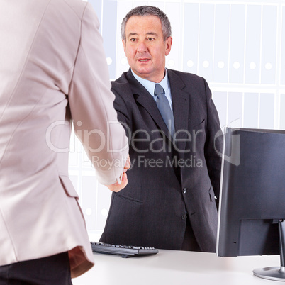 Businessman in office ranges woman's hand