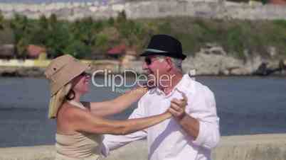 Old people traveling, senior couple dancing, kissing near the sea