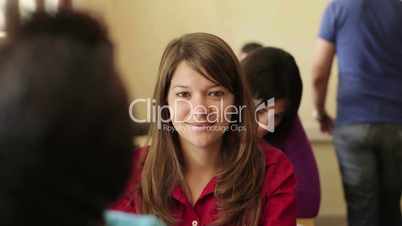 Happy caucasian young woman smiling during test in college