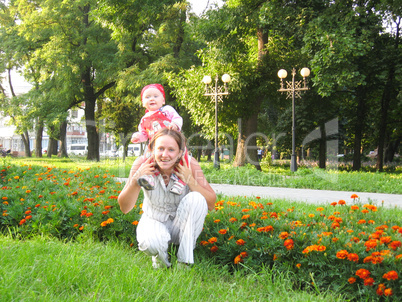 Happy mum and the daughter in park with flowers