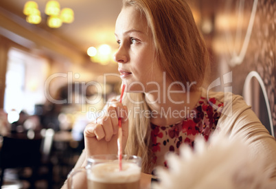 Girl is looking through the window in cafe.
