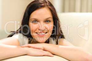 Smiling cheerful woman lying on couch