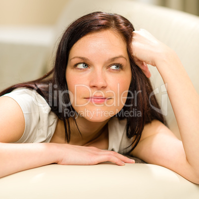 Thinking pensive woman lying in living room