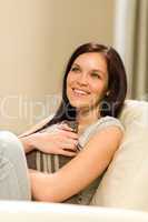 Joyful young woman sitting in armchair