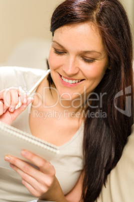 Young relaxed woman writing her diary