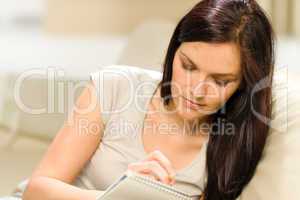 Young woman writing letter to copybook