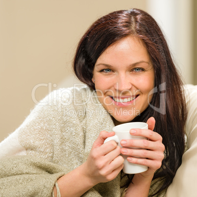 Portrait of joyful woman drinking hot beverage