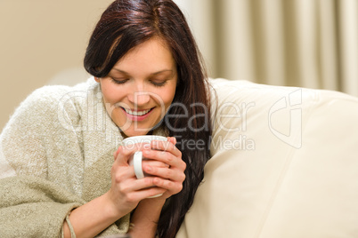Smiling woman enjoying hot tea