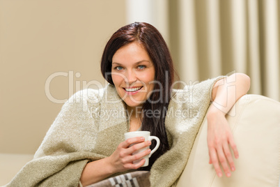 Joyful cozy woman drinking hot drink