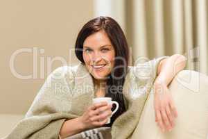 Joyful cozy woman drinking hot drink