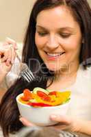 Cute woman eating fresh bowl of vegetables