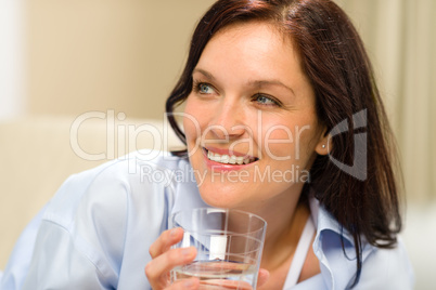 Smiling brunette woman with glass of water