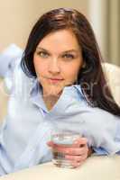 Woman looking camera holding glass of water