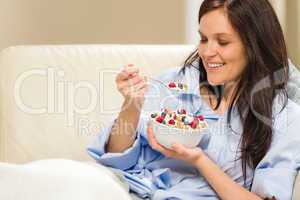 Young smiling woman eating healthy cereal