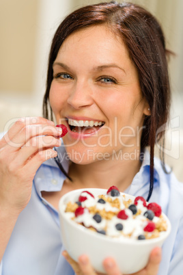 Joyful woman eating cereal in the morning
