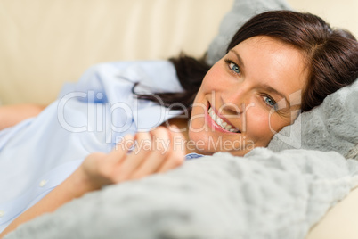Smiling brunette woman lying in bed